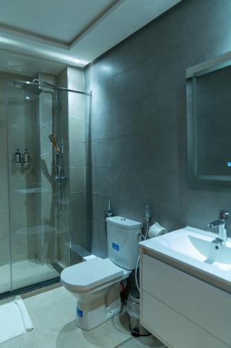 a bathroom with a toilet and a shower and a sink at Hotel Charf in Tangier
