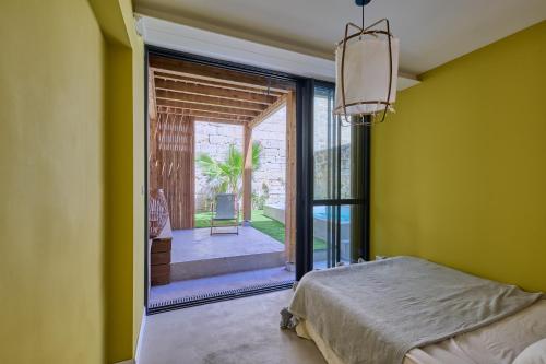 une chambre avec un lit et une porte coulissante en verre dans l'établissement Maison de charme plein centre de Bordeaux, à Bordeaux