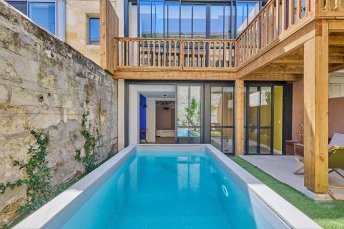 une maison avec une piscine et une terrasse en bois dans l'établissement Maison de charme plein centre de Bordeaux, à Bordeaux