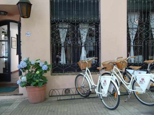 duas bicicletas estacionadas em frente a um edifício em Posada de la Flor em Colônia do Sacramento