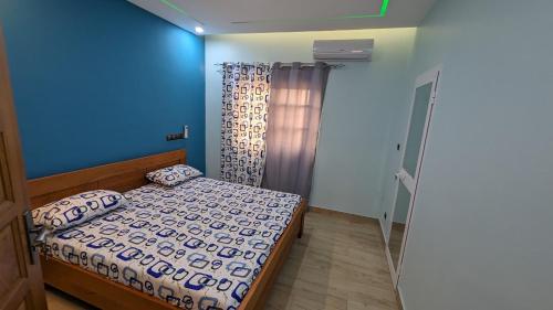洛美Clarisse Lodge Rez的一间带床和蓝色墙壁的卧室