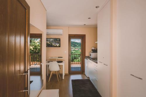 a small kitchen with a table and a desk at Quinta do Lameiro in Tarouca