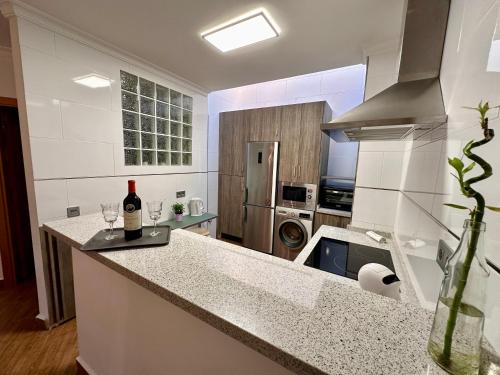 a kitchen with a bottle of wine on a counter at THE HOUSE IN TOQUERO Solarium views to the Alcazaba in Málaga