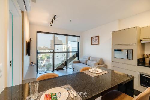 a kitchen and living room with a large window at MHF II - Apts Variados em Prédio com Vista para o Mar em Itapema in Itapema