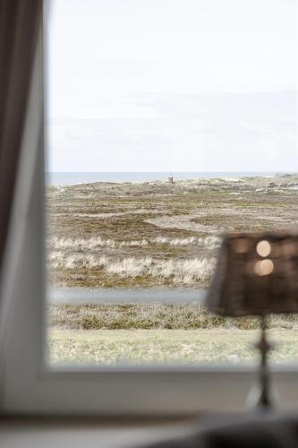a view of a beach from a window at Strönhof Kampen in Kampen