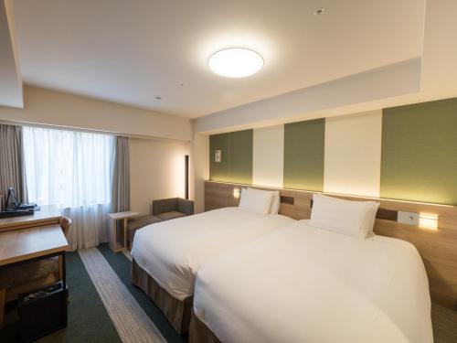 a hotel room with two beds and a window at Richmond Hotel Tenjin Nishi-Dori in Fukuoka