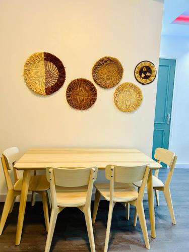a table and chairs with plates on the wall at BeHomu Apartments Kampala in Kira