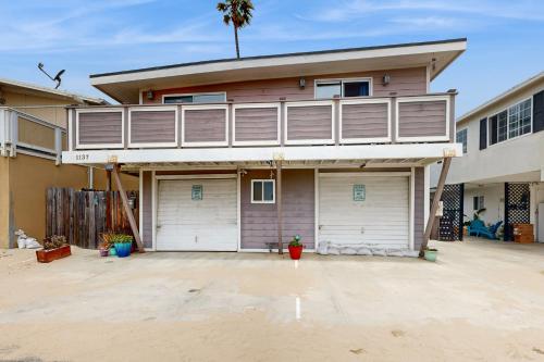 a house with two garage doors in front of it at Sailaway Cabin in Ventura