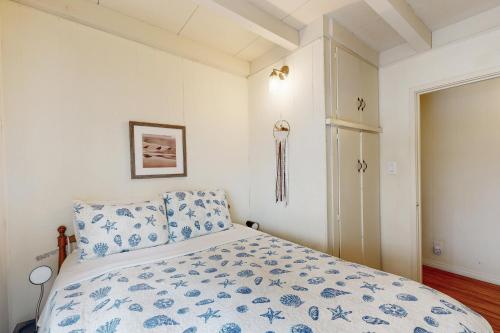 a bedroom with a bed with a blue and white comforter at Sailaway Cabin in Ventura