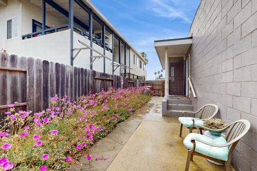 a garden with pink flowers next to a building at Sailaway Cabin in Ventura