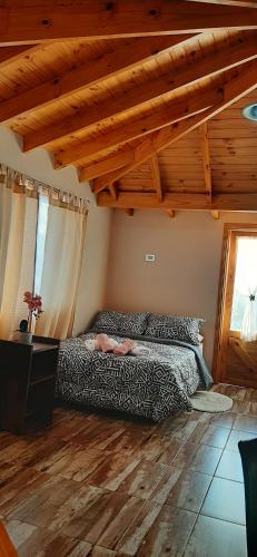 a bedroom with a bed and a wooden ceiling at your-space in El Calafate