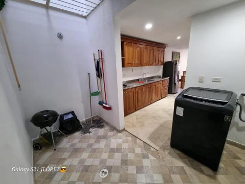 a kitchen with a black refrigerator and wooden cabinets at La Casa Perfecta para Grupos en el Centro in Rionegro