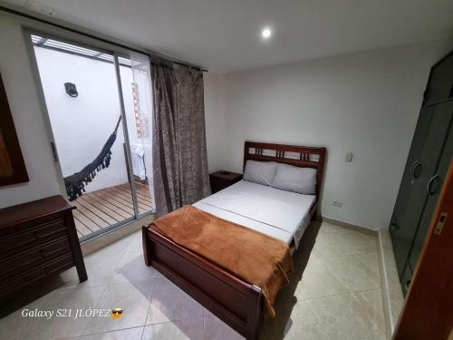 a bedroom with a bed and a large window at La Casa Perfecta para Grupos en el Centro in Rionegro