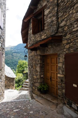 a stone building with a wooden door on a street at Apartaments Ca de Badia in Taull