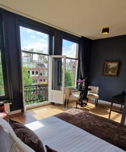 a bedroom with a bed and large windows at Canal House The Tannery Amsterdam in Amsterdam