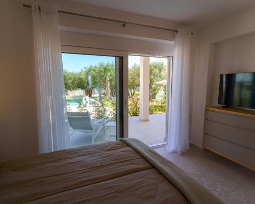 ヴォディツェにあるO`Life Boutique Apartmentsのベッドルーム(ベッド1台、テレビ、パティオ付)