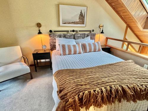 a bedroom with a large bed and a chair at Cozy Townhome at Lutsen Mtn - Ski-in, Ski-out, Pool, Hot Tub, Fitness Center, resort amenities galore! in Lutsen