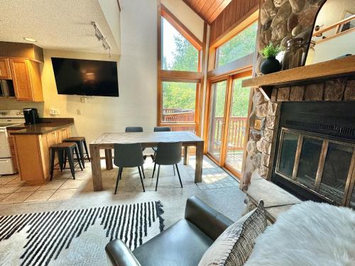 a living room with a table and a fireplace at Cozy Townhome at Lutsen Mtn - Ski-in, Ski-out, Pool, Hot Tub, Fitness Center, resort amenities galore! in Lutsen