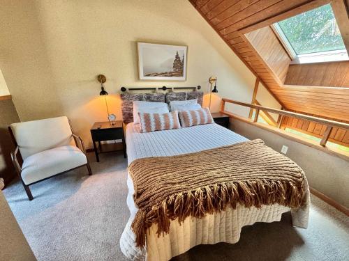 a bedroom with a large bed and a chair at Cozy Townhome at Lutsen Mtn - Ski-in, Ski-out, Pool, Hot Tub, Fitness Center, resort amenities galore! in Lutsen