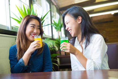 two women sitting at a table drinking drinks at Ryokan Yufusan in Yufuin
