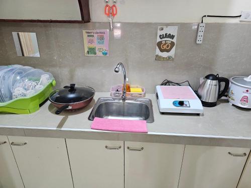 a kitchen counter top with a sink and a sink at budget transient house near sm Lucena 6pax in Lucena