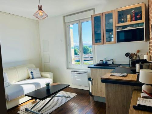 une cuisine et un salon avec un canapé et une table dans l'établissement Le Cocon au bord de la mer, à Trouville-sur-Mer