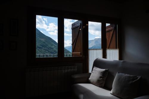 a living room with a couch and two windows at Apartaments Ca de Badia in Taull