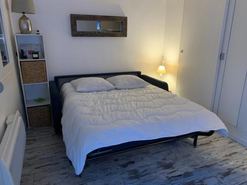 une chambre avec un grand lit avec des draps et des oreillers blancs dans l'établissement REPOS Au bord de la mer, à Villers-sur-Mer