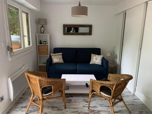 un salon avec un canapé bleu et deux chaises dans l'établissement REPOS Au bord de la mer, à Villers-sur-Mer