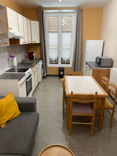 un salon avec une table et une cuisine dans l'établissement Charmant appartement centre ville proche thermes, à La Bourboule