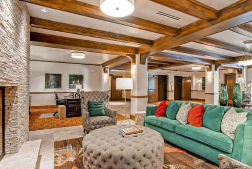 a living room with a green couch and a fireplace at Ascent 312 by East West Hospitality in Avon