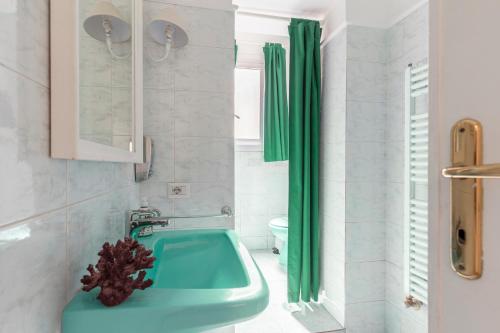 a bathroom with a green sink and a toilet at Piazza di Spagna Historic Flat in Rome