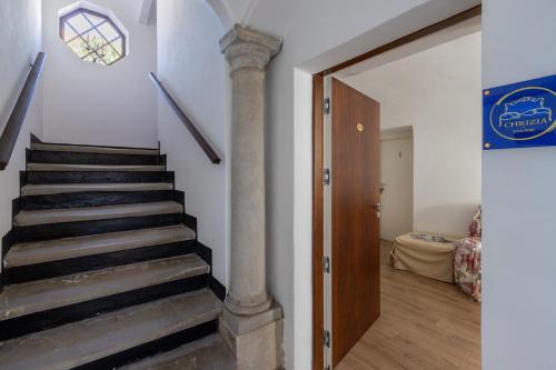 a staircase with a column in a room with a door at Chrizia in Novi Ligure