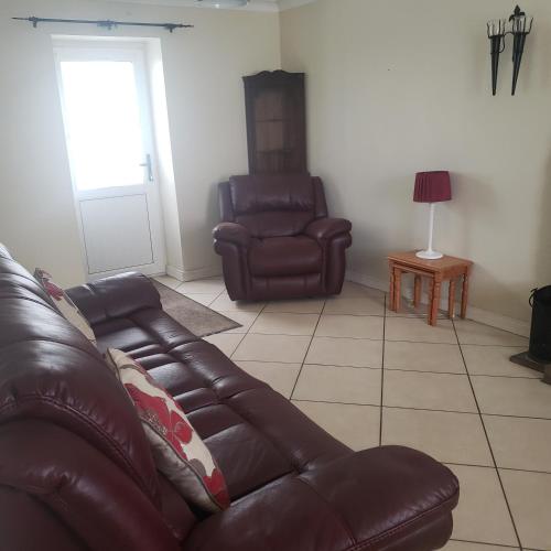 a living room with a leather couch and a chair at Oceanside Golf and Beach in Downings