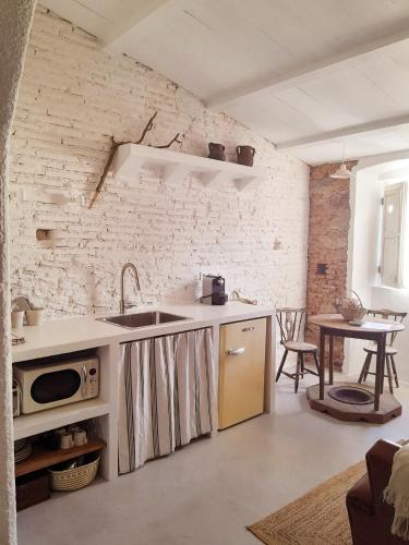 a kitchen with a sink and a table in a room at Casas Velhinhas - Apartº Aconchego e Apartº Calmaria in Estremoz