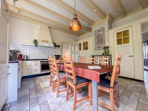 a kitchen with a wooden table and chairs at Bronzigt in Sluiskil