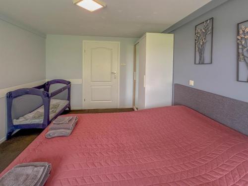 a bedroom with a large bed with a red blanket at Bronzigt in Sluiskil