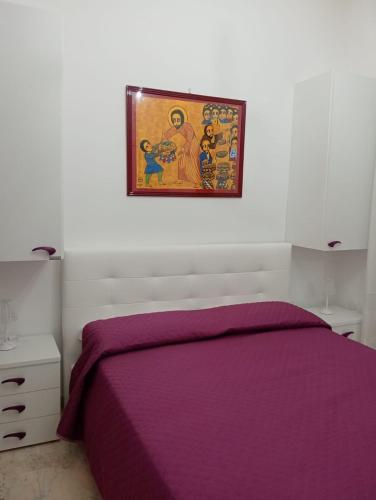 a bedroom with a purple bed and a picture on the wall at Palazzo Sardanelli in Pizzo