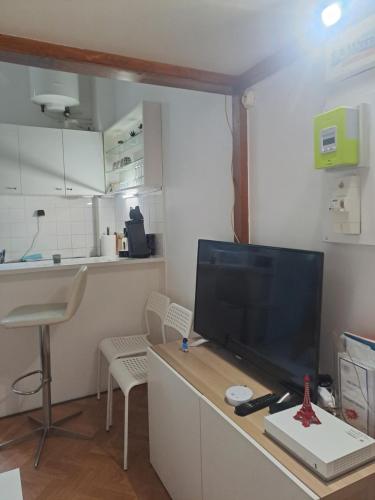 un salon avec une télévision à écran plat sur une table dans l'établissement Dominik, à Villejuif