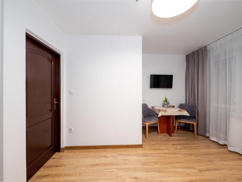 a room with a door and a table with chairs at Giewont in Murzasichle