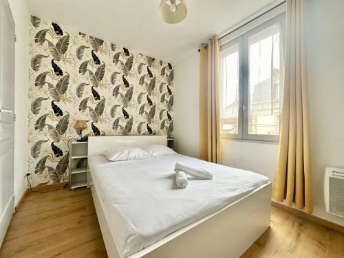 - une chambre avec un lit et un mur orné d'oiseaux dans l'établissement Le Saint Georges, cosy et calme, à Limoges