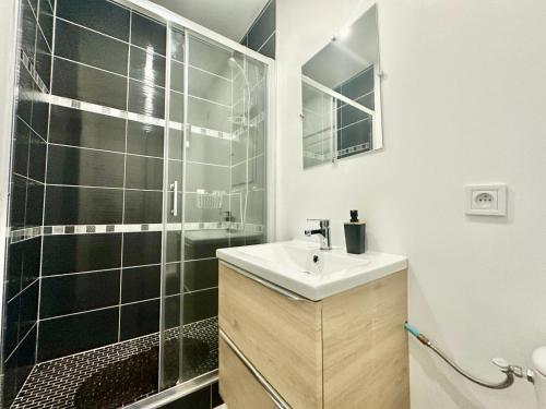 une salle de bain avec un lavabo et une douche dans l'établissement Le Saint Georges, cosy et calme, à Limoges