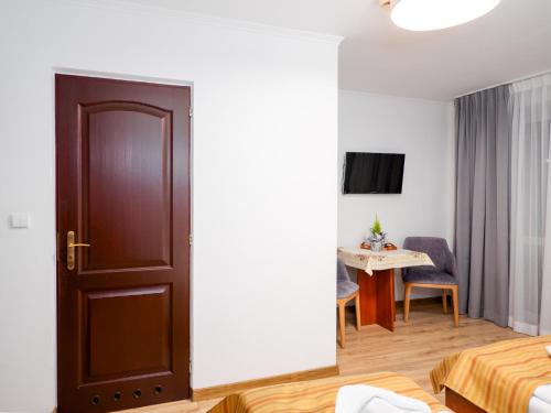 a room with a door leading to a room with a table at Giewont in Murzasichle