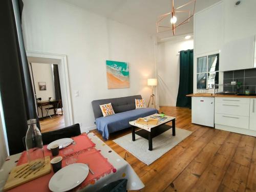 a living room with a blue couch and a table at Bel Appt-Quartier des halles-2 Pers-Animal accepté in Pau