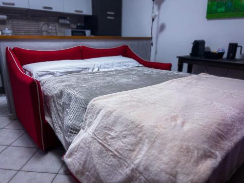 a bed with a red headboard and white sheets at Ca' Vittoria Urban Lodge in Alba