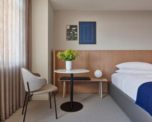 a hotel room with a bed and a table and chair at Hotel AKA Boston Common in Boston