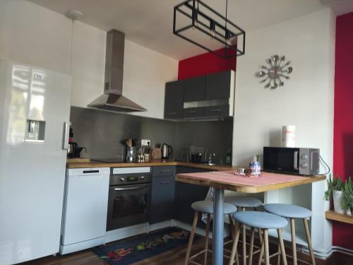 - une cuisine avec une table et quelques tabourets dans l'établissement lysiane, à Calais