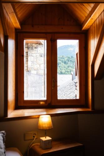 a window in a room with a lamp on a table at Apartaments Ca de Badia in Taull
