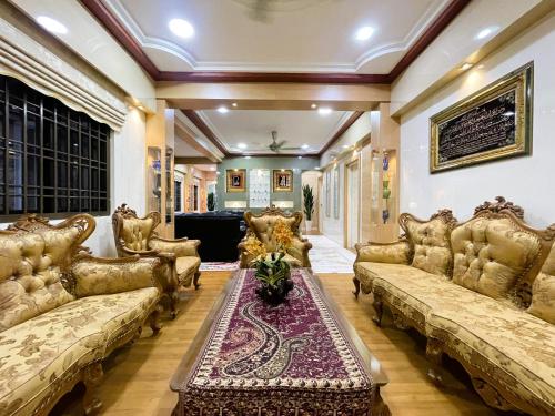 a large living room with couches and a table at Homestay & Pool Laman Sri Aman Pontian in Pontian Besar