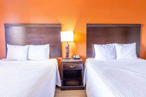 two beds in a hotel room with white sheets at Days Inn by Wyndham Oklahoma City/Moore in Oklahoma City